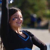 Laker Dancers with GV cheek tattoo with right arm raised and left arm on hip